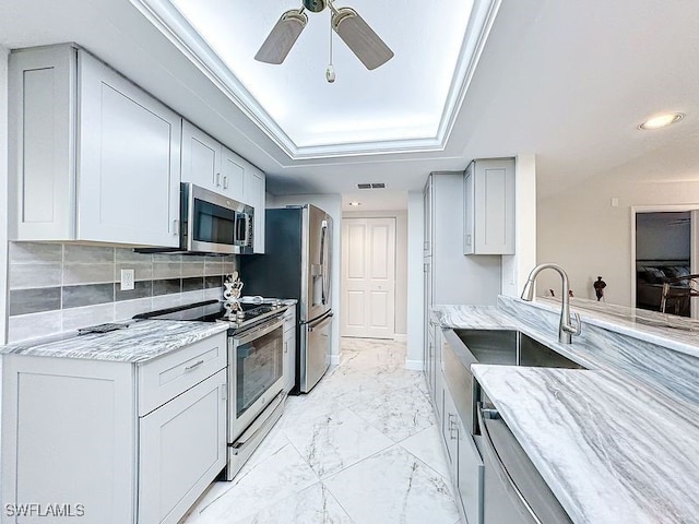 kitchen with visible vents, ceiling fan, light stone counters, marble finish floor, and stainless steel appliances