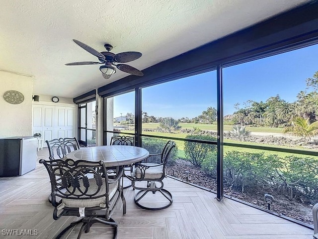 sunroom / solarium featuring ceiling fan