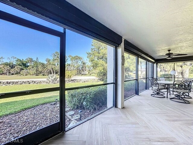 unfurnished sunroom with ceiling fan