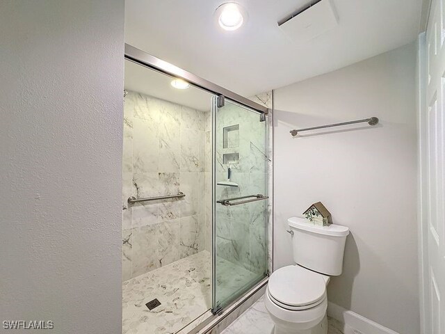 bathroom featuring toilet and an enclosed shower