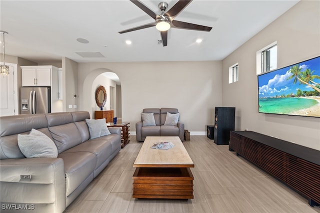 living room with baseboards, arched walkways, ceiling fan, and recessed lighting