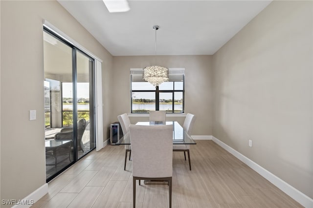 dining space with a water view and a notable chandelier