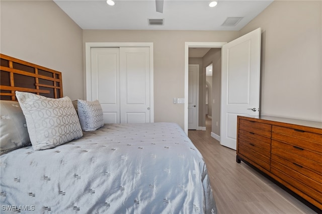 bedroom featuring baseboards, visible vents, a closet, and wood finished floors