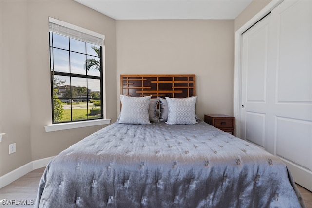 unfurnished bedroom with multiple windows, light wood-type flooring, and a closet