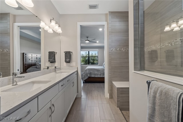 ensuite bathroom featuring a sink, double vanity, visible vents, and connected bathroom