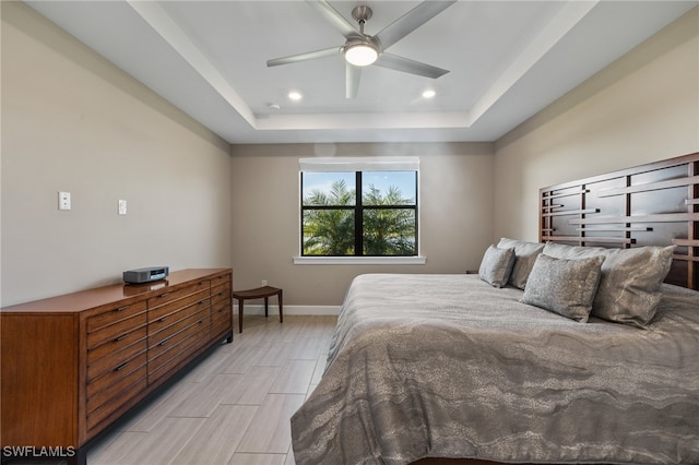 bedroom featuring ceiling fan, recessed lighting, a raised ceiling, and baseboards