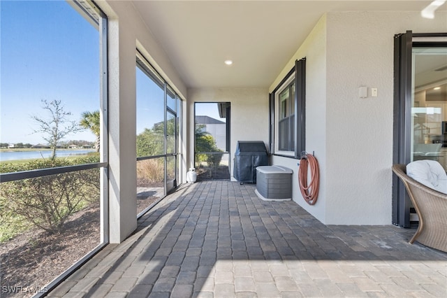 sunroom featuring a water view