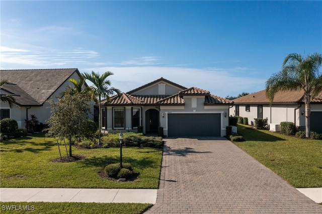 mediterranean / spanish-style house with a garage and a front lawn