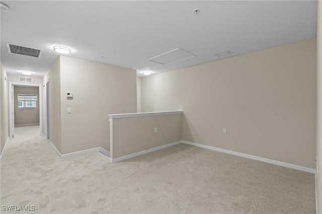 spare room with visible vents, baseboards, and light colored carpet