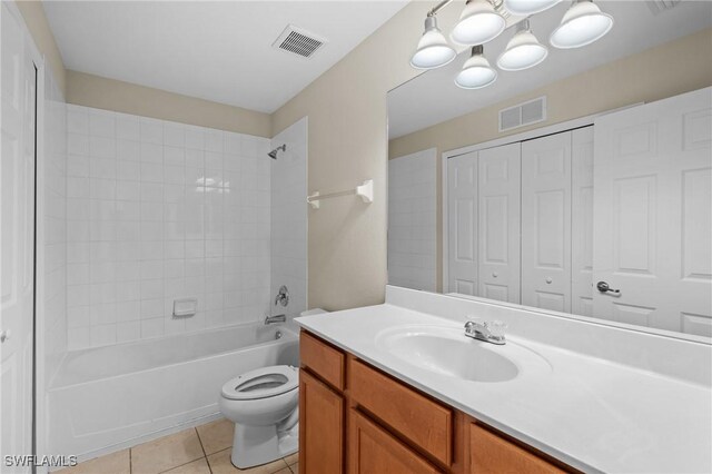 full bathroom with vanity, tiled shower / bath combo, tile patterned floors, and toilet