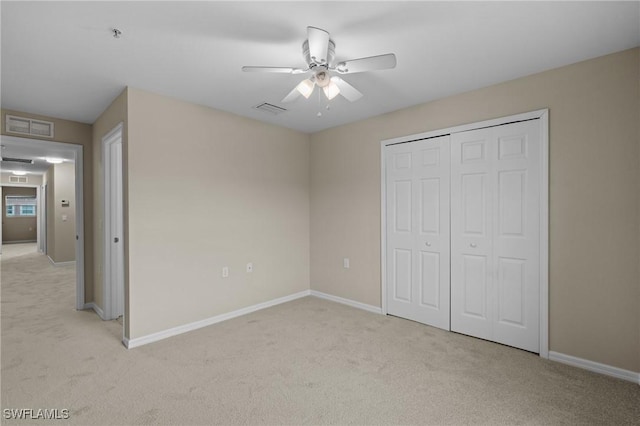 unfurnished bedroom featuring light carpet, a closet, and ceiling fan