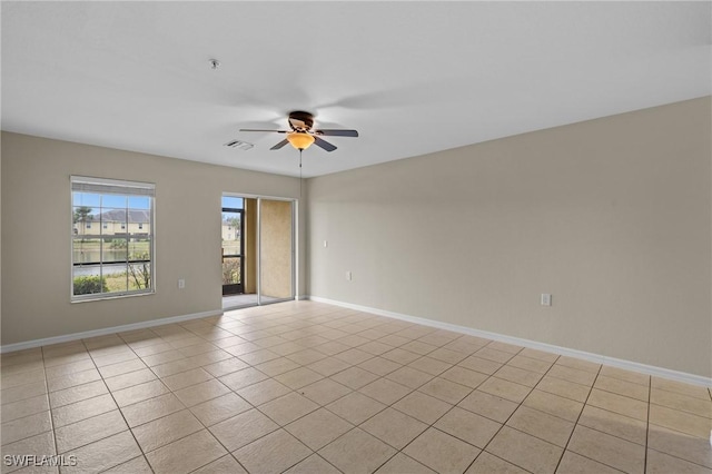 tiled spare room featuring ceiling fan