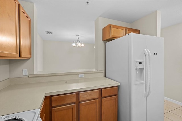 kitchen with light tile patterned flooring, range, a chandelier, hanging light fixtures, and white refrigerator with ice dispenser