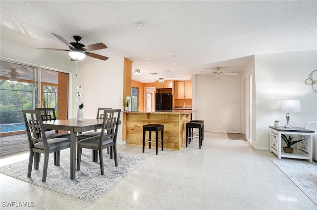 dining room featuring ceiling fan and a textured ceiling