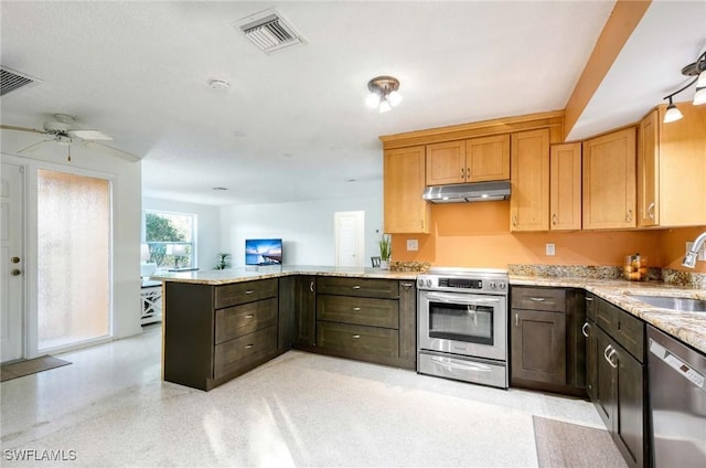 kitchen with kitchen peninsula, ceiling fan, stainless steel appliances, light stone counters, and sink