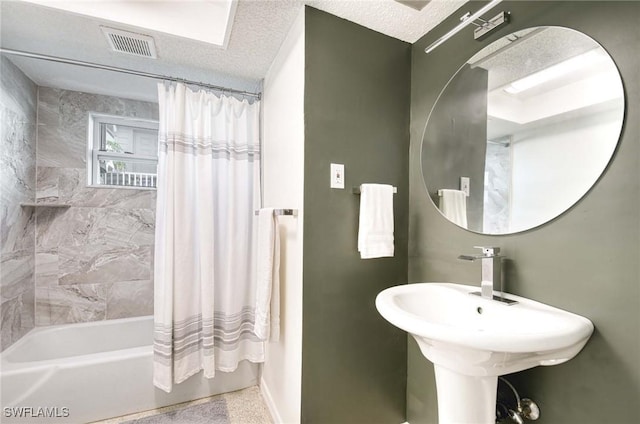 bathroom featuring sink, shower / bath combo with shower curtain, and a textured ceiling