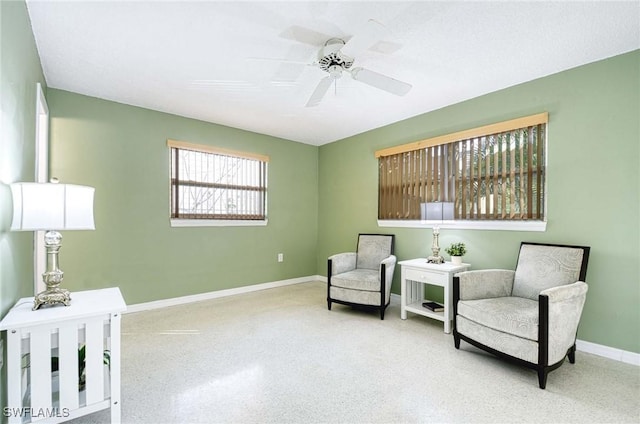 living area with a textured ceiling and ceiling fan