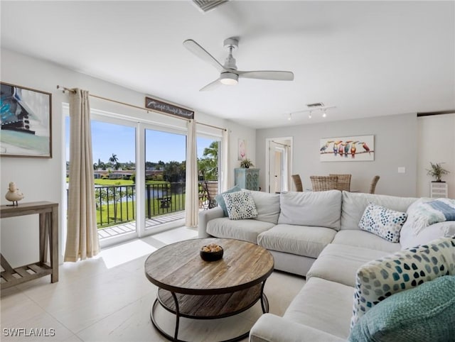 living room with a water view and ceiling fan