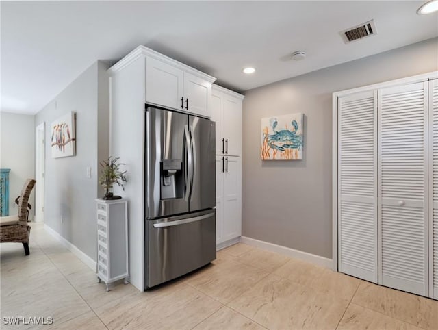 kitchen featuring white cabinets and stainless steel fridge with ice dispenser