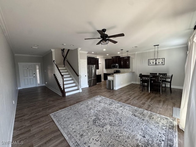 living room featuring crown molding, dark hardwood / wood-style flooring, and ceiling fan with notable chandelier