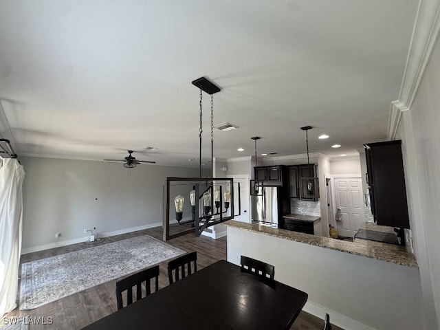 dining room featuring wood-type flooring, ceiling fan, and crown molding