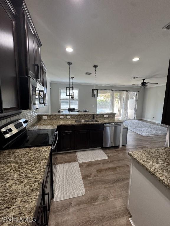 kitchen featuring ceiling fan, hanging light fixtures, stainless steel appliances, dark hardwood / wood-style floors, and dark brown cabinets