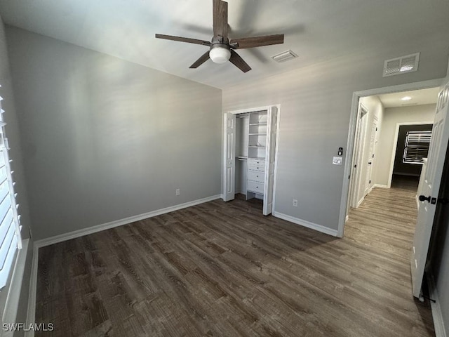 unfurnished bedroom featuring ceiling fan, dark hardwood / wood-style flooring, and a closet