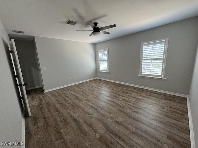 unfurnished room with a wealth of natural light, dark hardwood / wood-style flooring, and ceiling fan