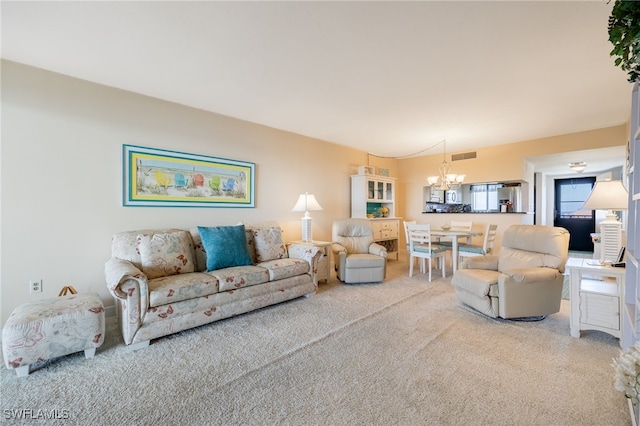 carpeted living room with a chandelier