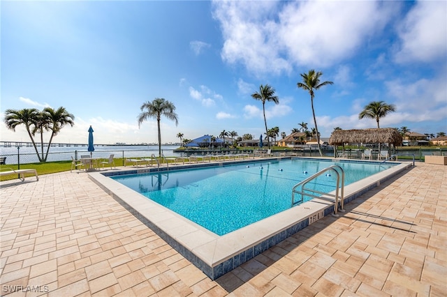 view of pool with a patio area and a water view