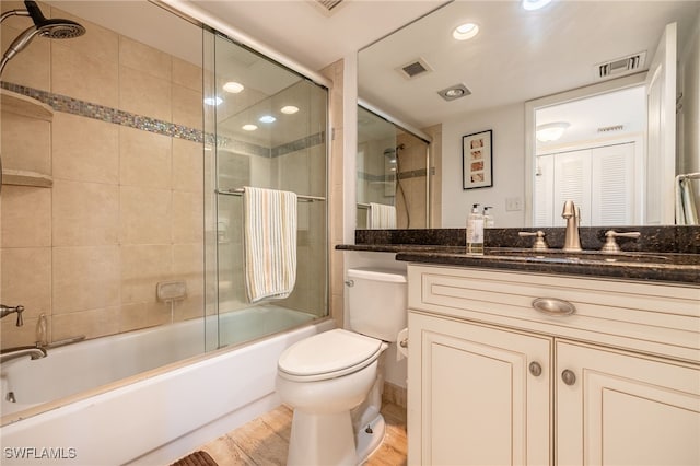 full bathroom featuring shower / bath combination with glass door, wood-type flooring, vanity, and toilet