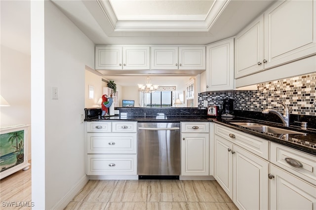 kitchen with stainless steel dishwasher, a raised ceiling, sink, dark stone countertops, and white cabinets