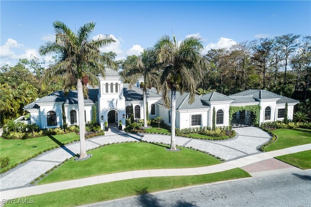 mediterranean / spanish house featuring a front lawn