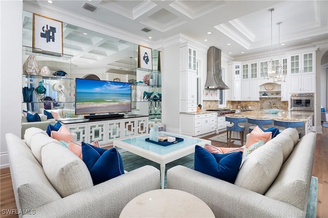 living room featuring hardwood / wood-style flooring, beam ceiling, ornamental molding, and coffered ceiling