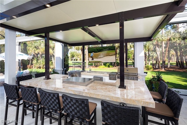 view of patio with area for grilling and an outdoor bar