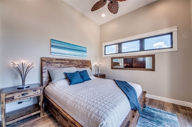 bedroom with hardwood / wood-style flooring, ceiling fan, and vaulted ceiling