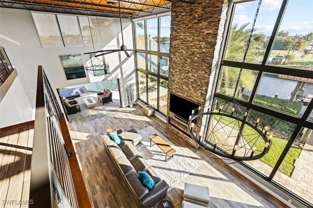 sunroom / solarium featuring a stone fireplace and a healthy amount of sunlight