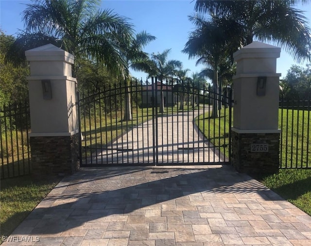 view of gate with a yard