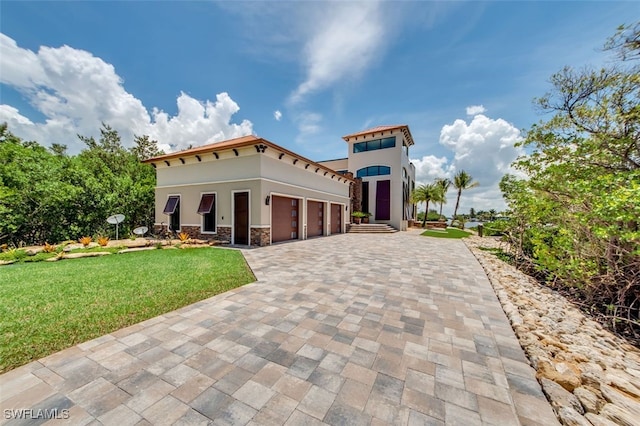 mediterranean / spanish home with a garage and a front lawn