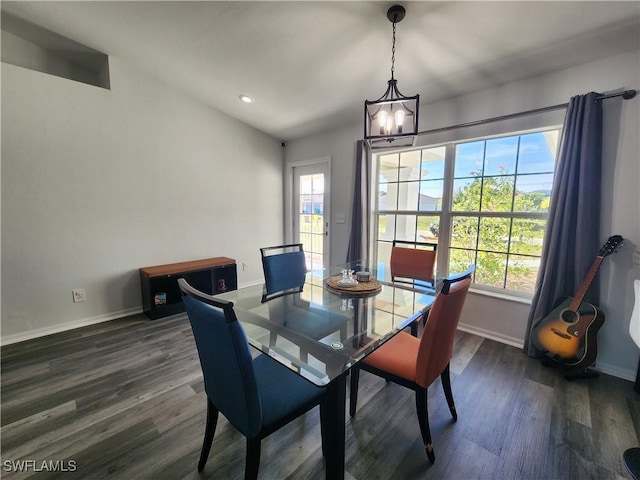 dining area with dark hardwood / wood-style floors and a notable chandelier