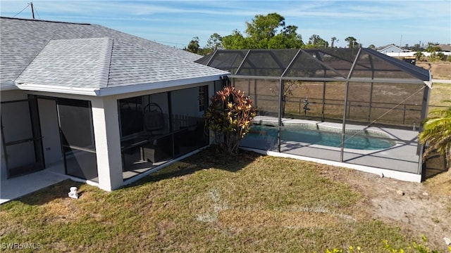 rear view of house with a lanai and a yard