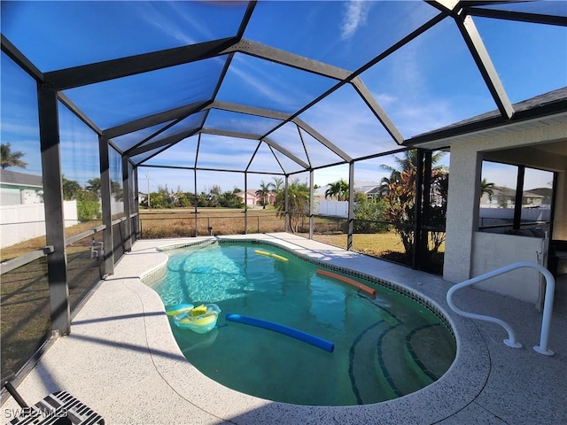 view of pool featuring glass enclosure and a patio area