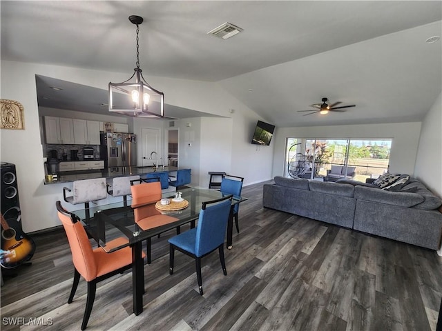 dining room featuring sink, ceiling fan with notable chandelier, dark wood-type flooring, and lofted ceiling