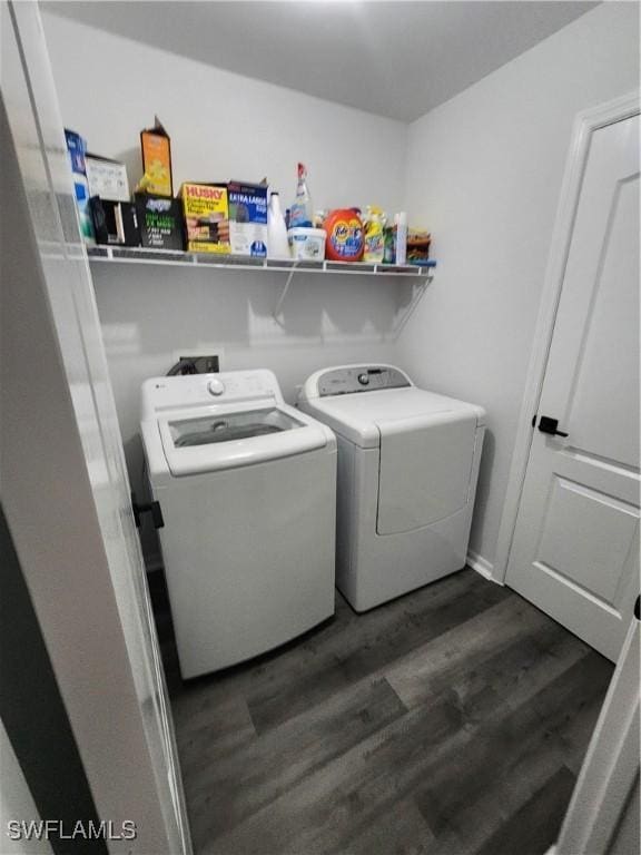 clothes washing area with dark hardwood / wood-style flooring and separate washer and dryer