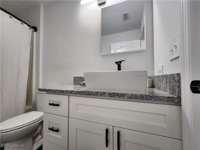 full bathroom featuring shower / tub combo with curtain, vanity, and toilet