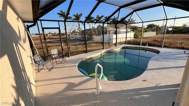 view of pool featuring glass enclosure and a patio area