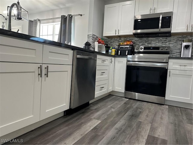 kitchen with decorative backsplash, stainless steel appliances, white cabinetry, and dark hardwood / wood-style floors