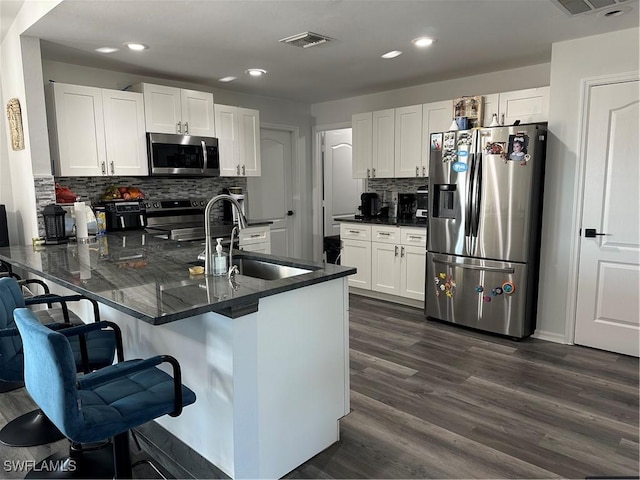 kitchen with white cabinets, sink, kitchen peninsula, and stainless steel appliances