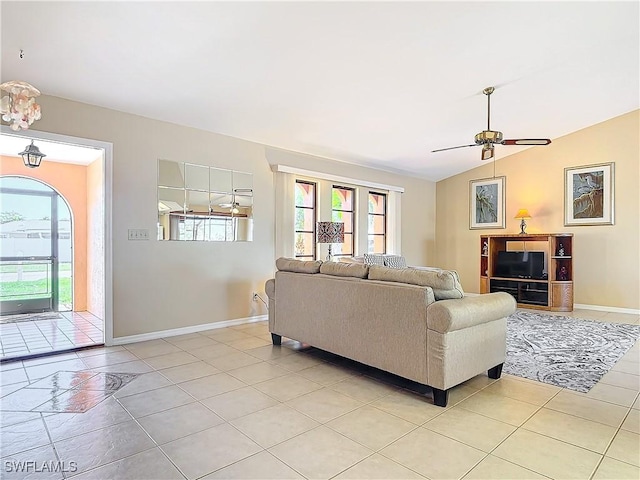 tiled living room with ceiling fan and vaulted ceiling