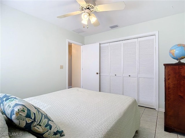 tiled bedroom featuring ceiling fan and a closet